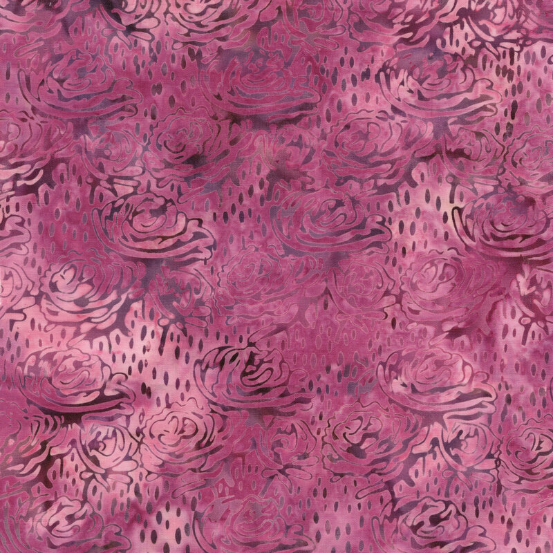 A mottled muted pink batik fabric with abstract flowers and seeds. 