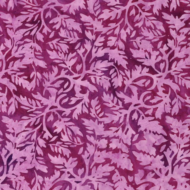 A mottled plum pink batik fabric with pink leaves.