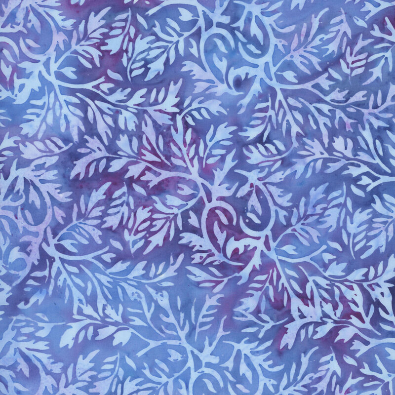 A mottled iris blue batik fabric with baby blue leaves. 