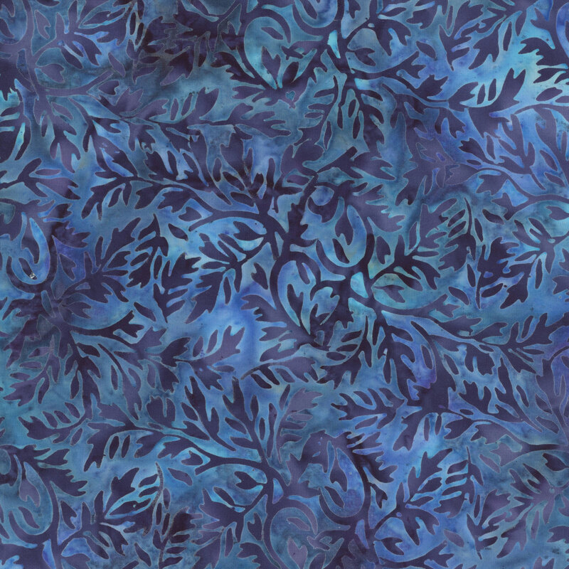 A mottled teal and blue batik fabric with dark denim leaves.