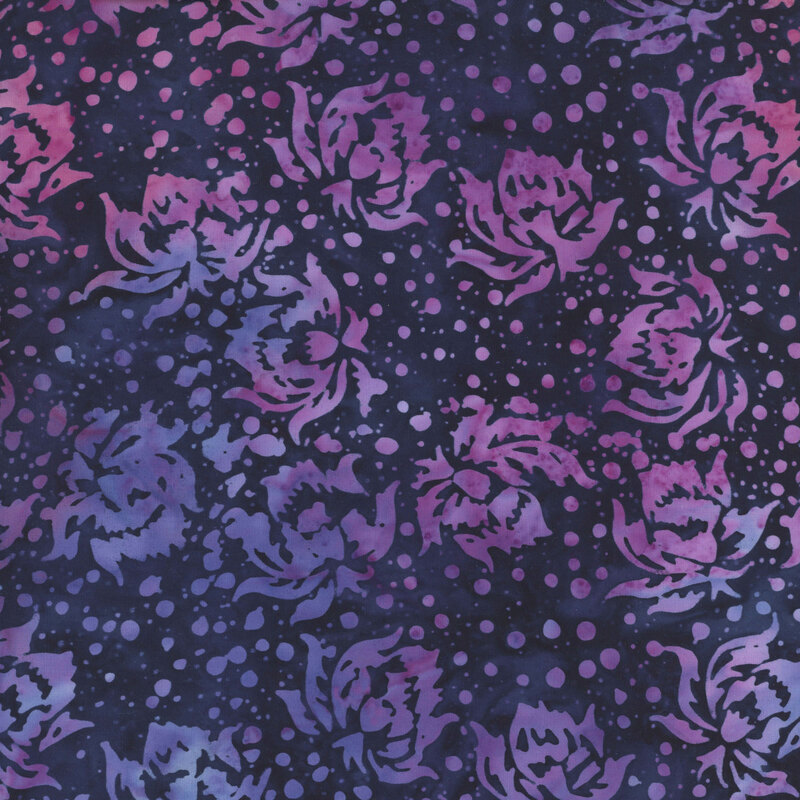 This mottled dark indigo batik fabric features magenta and iris blue flowers and dots.