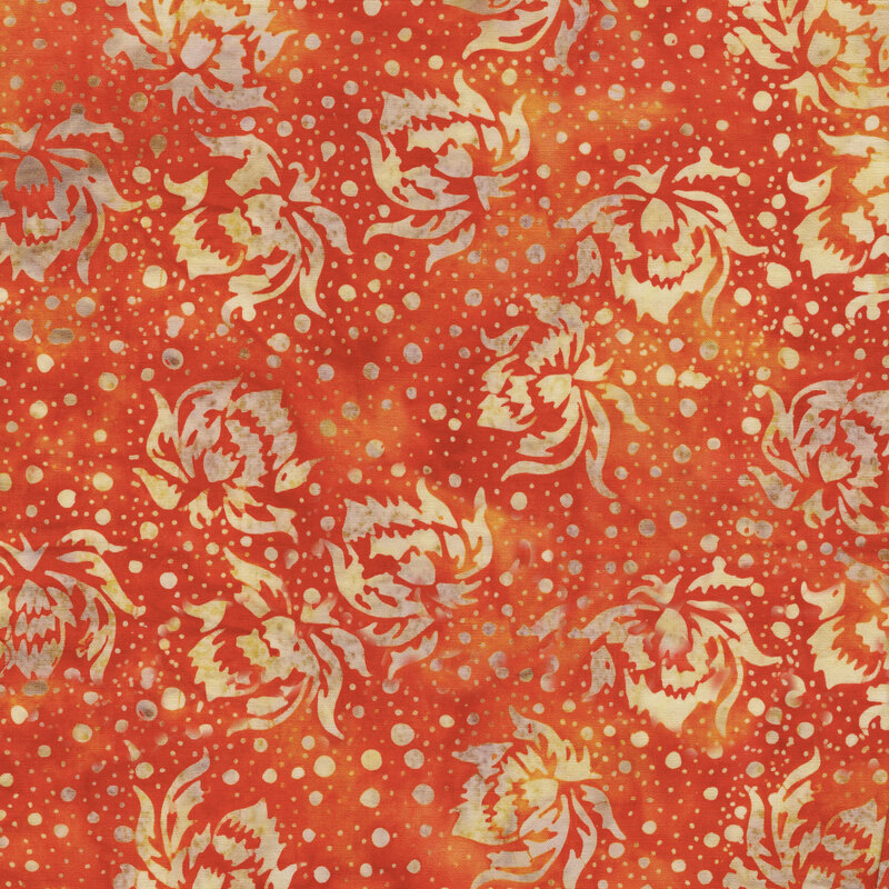 A bright orange batik with buff flowers and dots. 