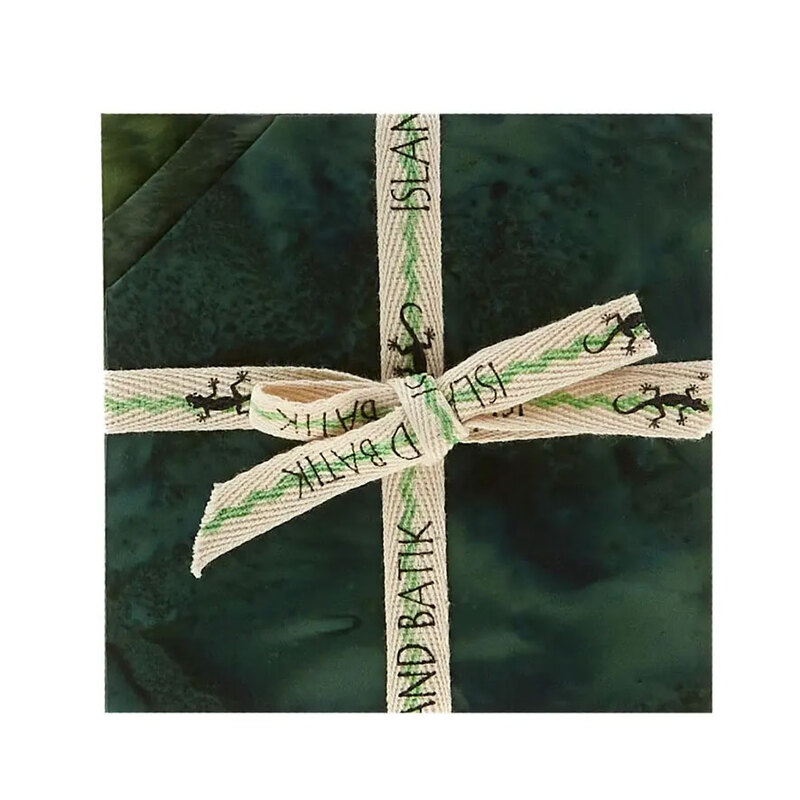 Layered stack of green mottled fabrics with the upper left corners folded, tied in an “Island Batik” ribbon.