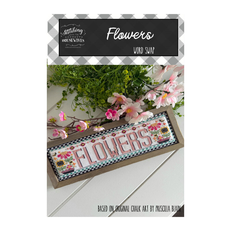A framed cross stitch sign displaying the word FLOWERS with decorative florals and a white paneled background.
