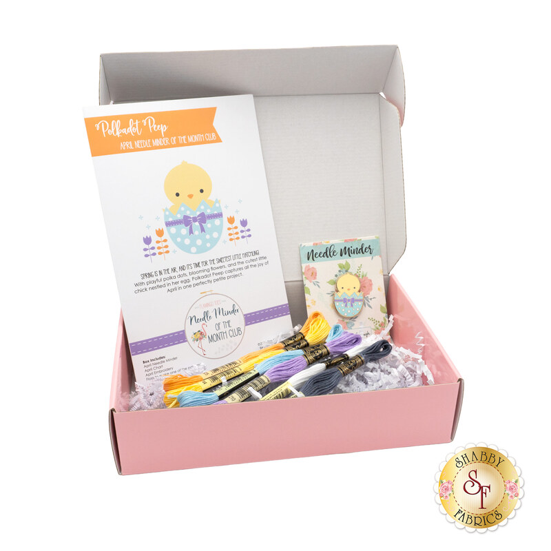 The open April kit, a pink box containing colorful embroidery threads, a project guide, and a small pattern card.