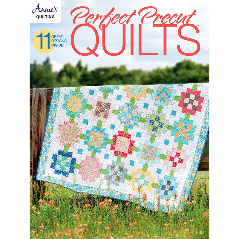 The front of the Perfect Precut Quilts Book showing a finished quilt draped over a fence in a grassy field and the book title in red across the top.