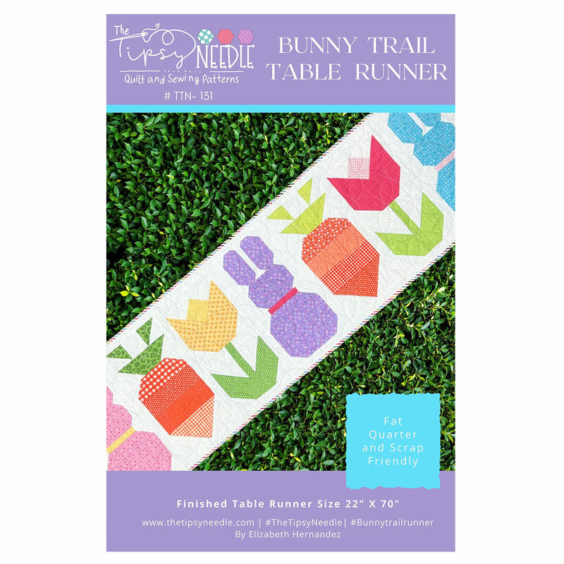 Cover of the Bunny Trail Table Runner pattern featuring a colorful table runner design composed of rabbits, tulips and carrots.