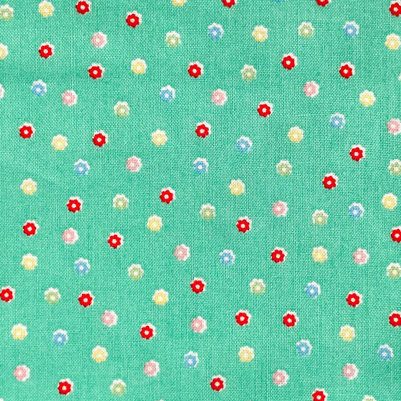 Green fabric with a scattered pattern of colorful flower buds.