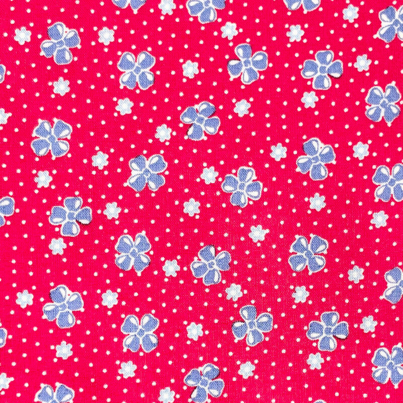Bright red fabric features a vintage-style pattern of floral buds set against a dotted background.
