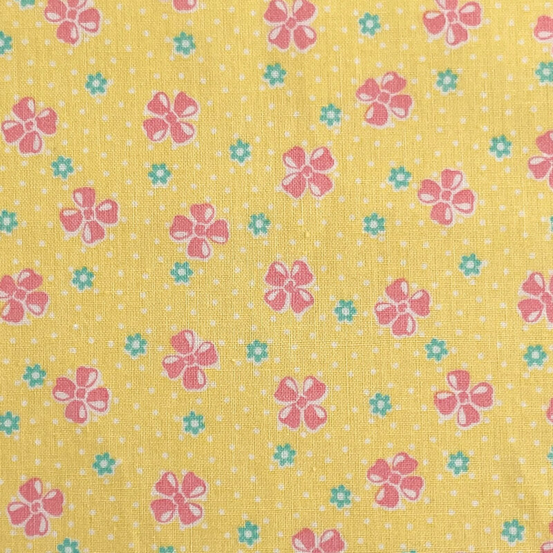 Yellow fabric with a vintage-style pattern of floral buds set against a dotted background.