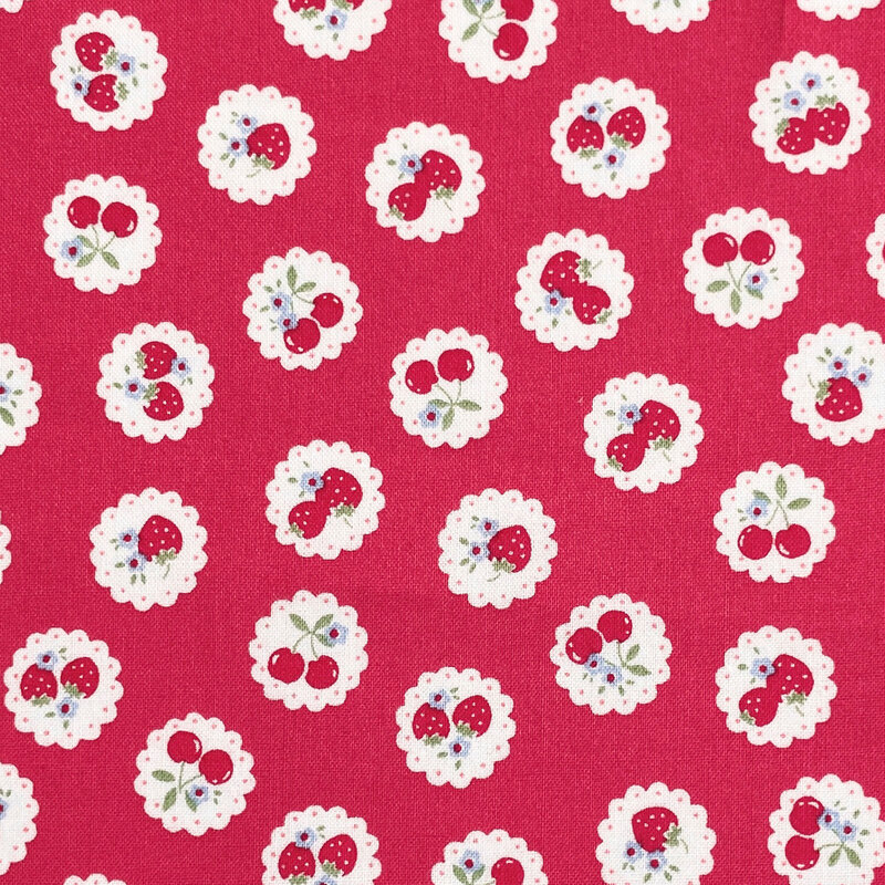 red fabric with a pattern of vintage-style medallions filled with assorted fruits like cherries and strawberries.