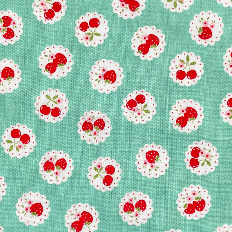 Aqua green fabric with a pattern of vintage-style medallions filled with assorted fruits like cherries and strawberries.