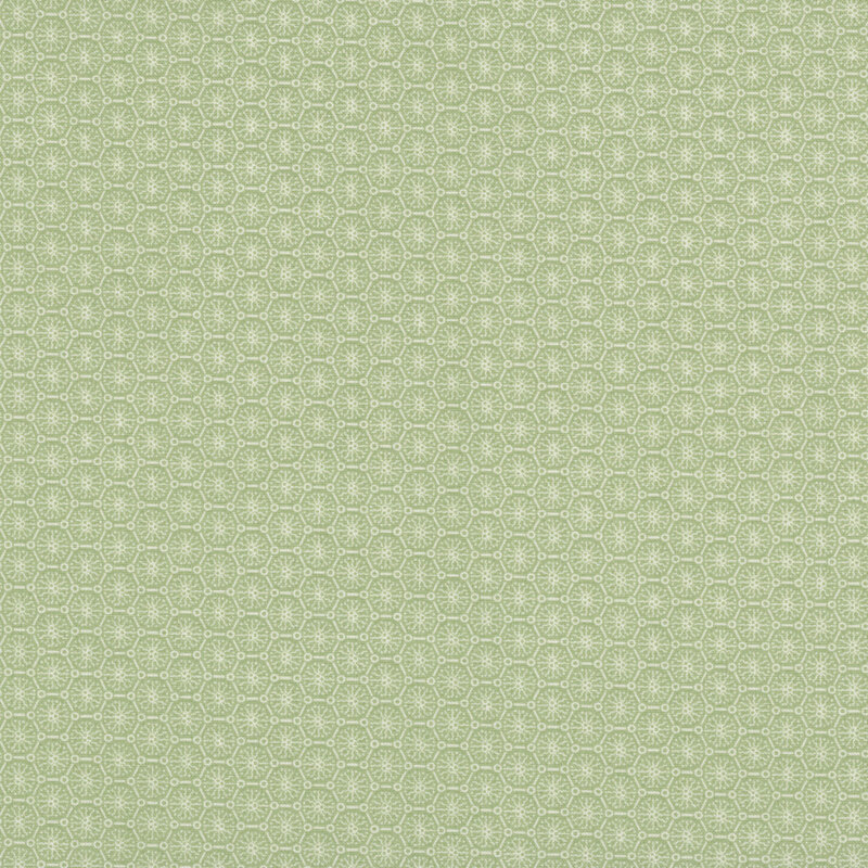 Green fabric with a tonal, stylized geometric design of abstract flowers arranged within an octagonal lattice.