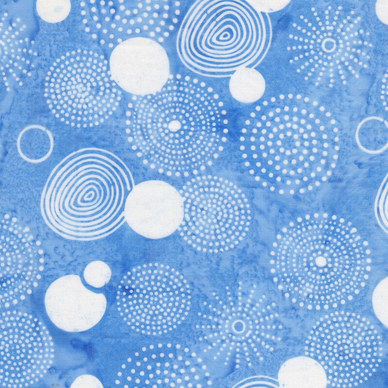 Mottled sky blue batik fabric with a white overlay of spirals, circles, and bursts of dots