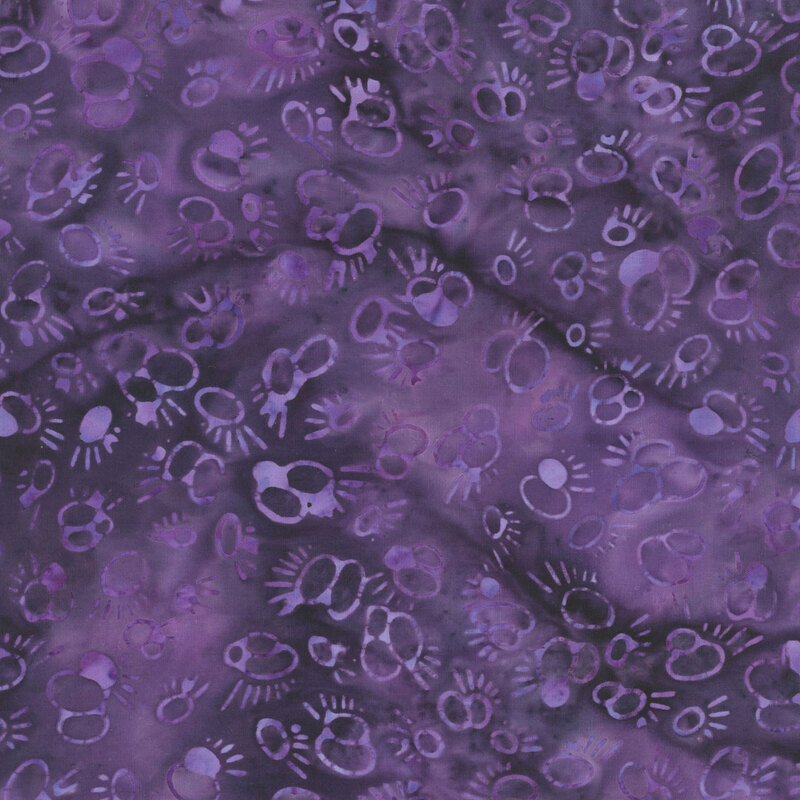 Tonal abstract circle and dashed motifs on a mottled dark purple fabric.