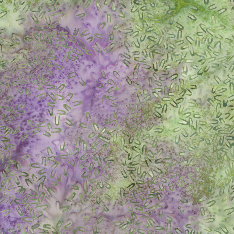 Mottled green and purple fabric with green hairpin shaped motifs scattered throughout.