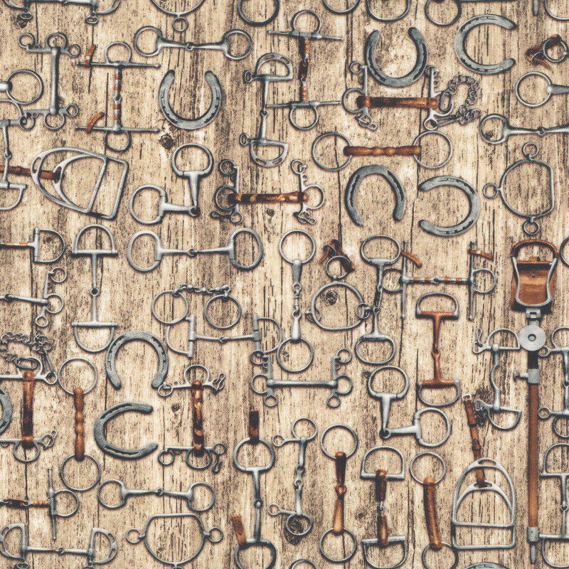 A variety of spurs and horseshoes on a light wood background.