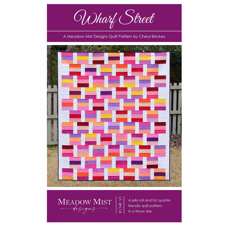 The front of the Wharf Street pattern with photo of finished quilt staged in front of a white fence.