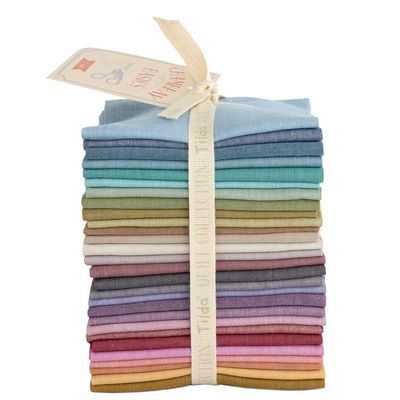 A stack of folded fat eighths in various colors, neatly tied with a ribbon label.