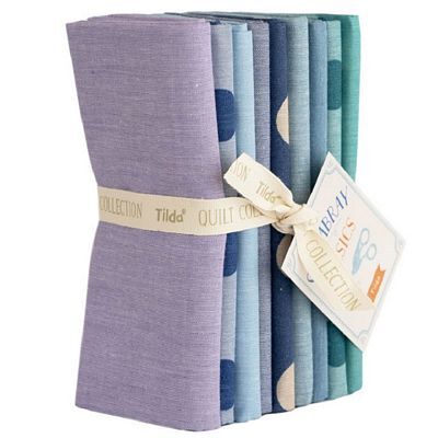 A stacked bundle of assorted Tilda Chambray fabrics in teal, purple, and blue, tied with a label.