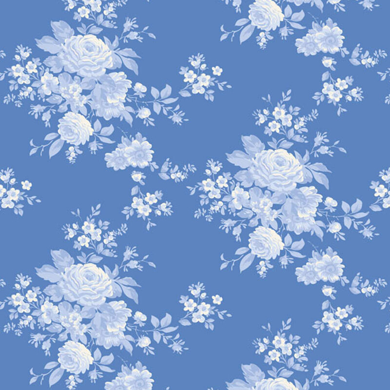 Blue fabric with floral clusters in a classic toile style, creating an elegant, timeless design.