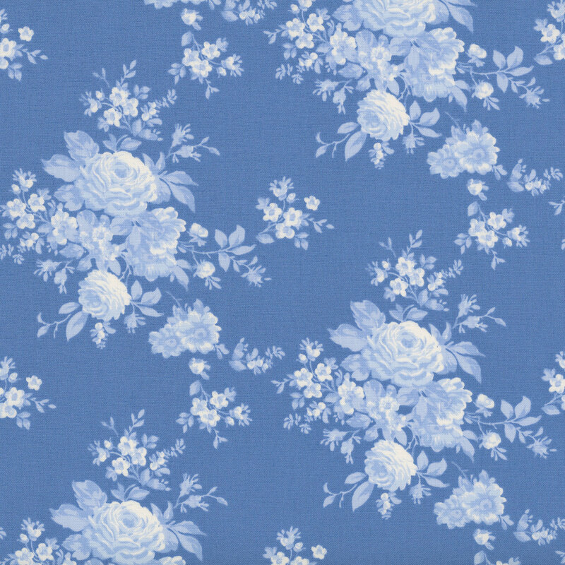 Blue fabric with floral clusters in a classic toile style, creating an elegant, timeless design.