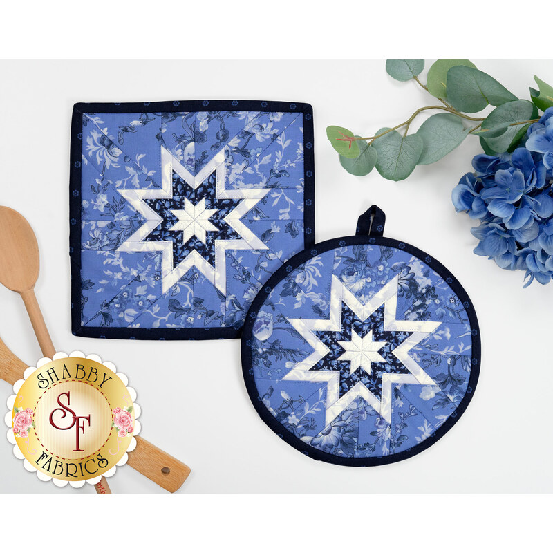 The completed Folded Hot Star Pads in dark blue, blue, and light blue fabrics from the Blue Belle collection by Maywood Studio, staged on a white table with coordinating decor.
