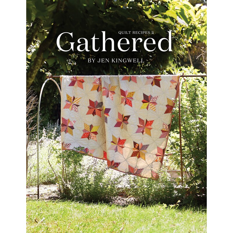 Front cover of the pattern, showing a beautiful patchwork star quilt draped over a fixture outdoors in a green garden on a sunny day.