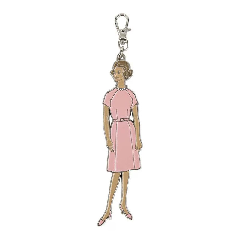 Silver keychain charm in the shape of a woman dressed in 50's fashion.