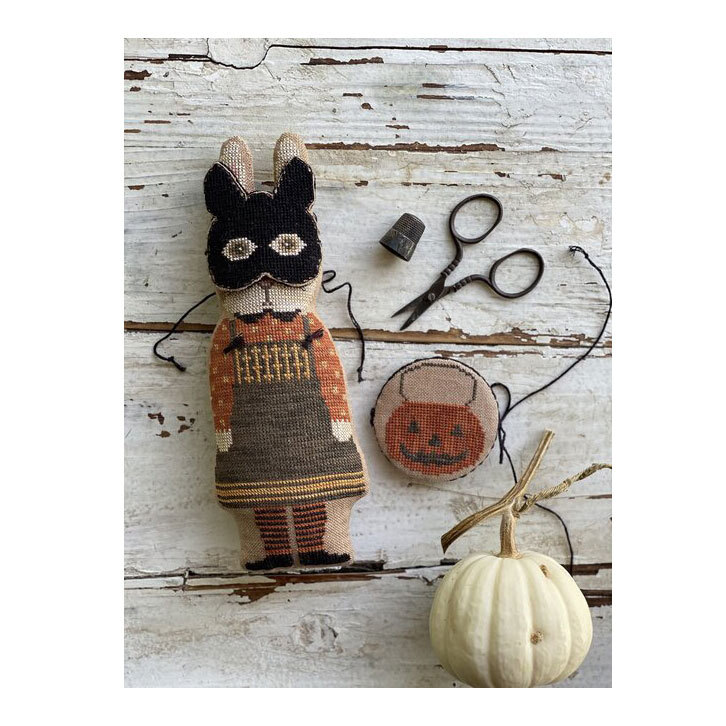 Image of the completed project "Nettle" featuring a masked rabbit and a pumpkin bucket needle book.