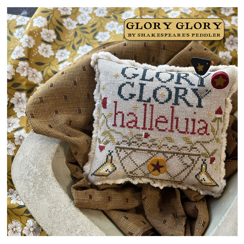 The finished cross stitch pattern in a bowl surrounded by coordinating décor. 