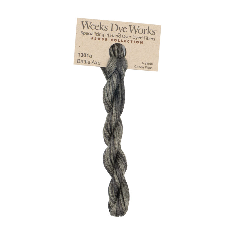 A skein of steel gray embroidery floss, twisted and bundled, with a tan label featuring the brand name and color information.