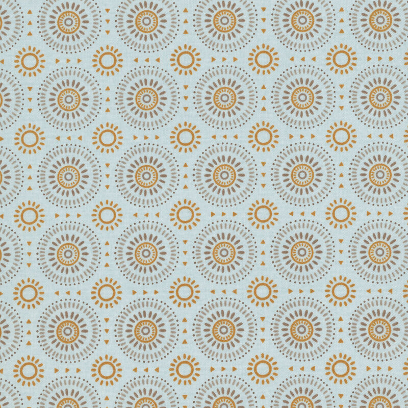 Dusty blue fabric featuring a geometric sunburst pattern in hues of gold, tan, and taupe. 