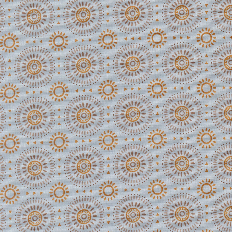 Dusty blue fabric featuring a geometric sunburst pattern in hues of gold, tan, and taupe. 