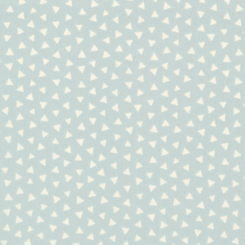 Dusty blue fabric featuring a tossed pattern of ivory triangles.