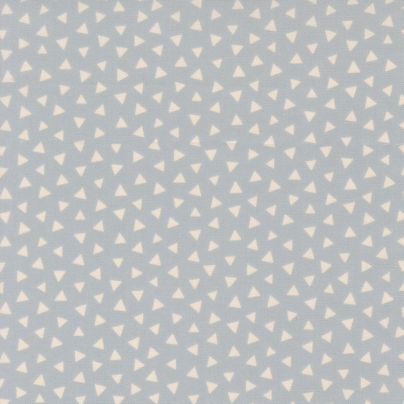 Dusty blue fabric featuring a tossed pattern of ivory triangles.