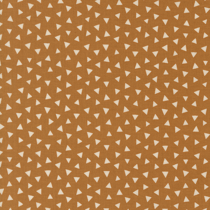 Warm caramel fabric featuring a tossed pattern of light beige triangles.
