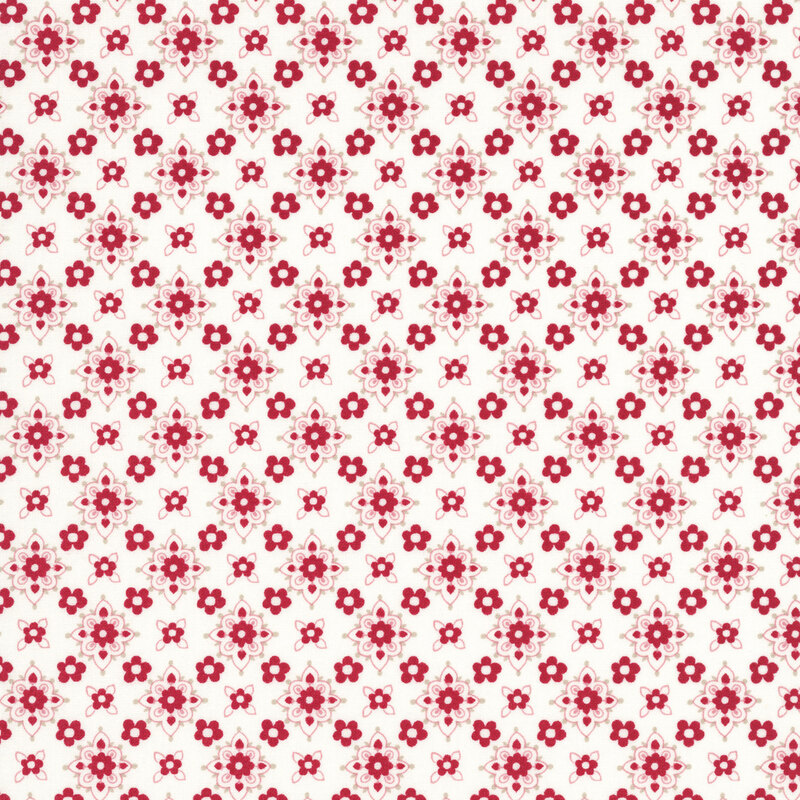 White fabric featuring a repeating pattern of small red florals with stylized floral medallions in hues of red, peach, and taupe.