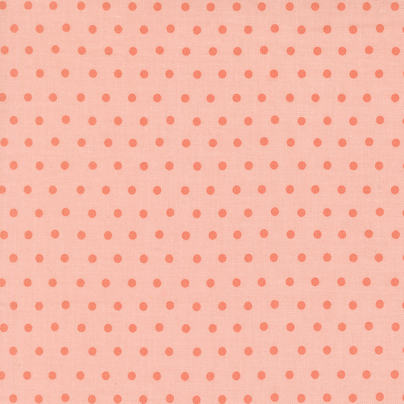 Peach fabric with a coral polka dot pattern.