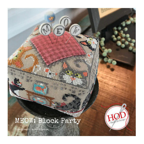 An image of the completed project featuring cats, a wool houndstooth square, and embellished pins sticking out.