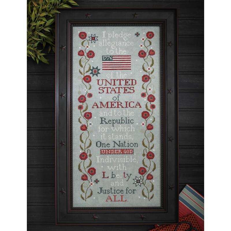 The completed project featuring the stitched Pledge of Allegiance, surrounded by red flowers and an American flag.