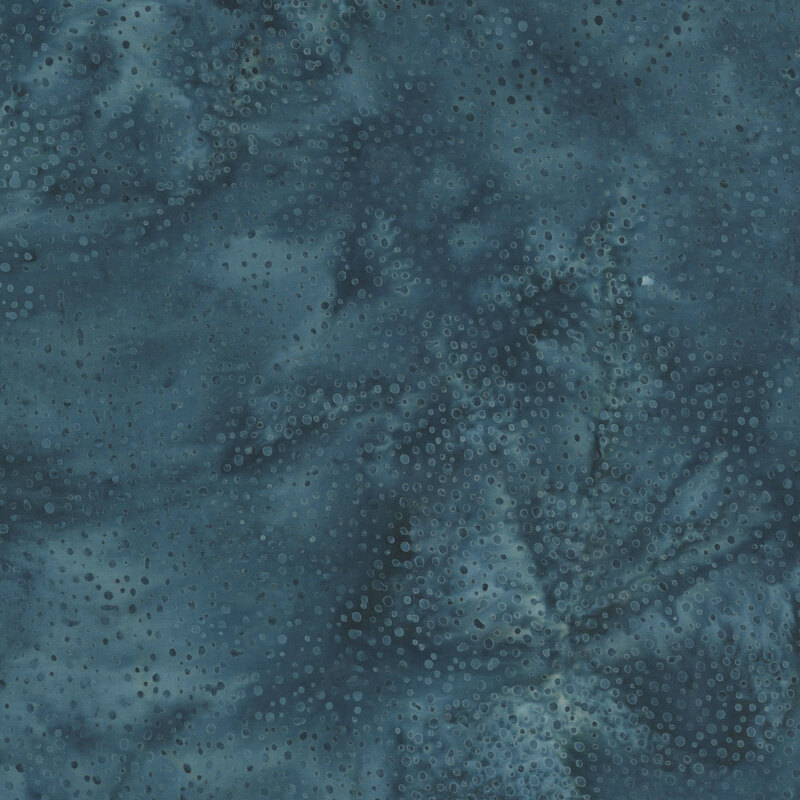 blue fabric with a pattern of tonal dots on a mottled background.