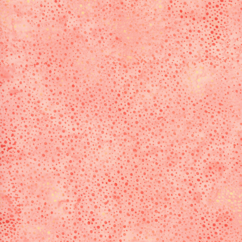Swatch of peachy pink tonal batik with mottling and irregular dots.