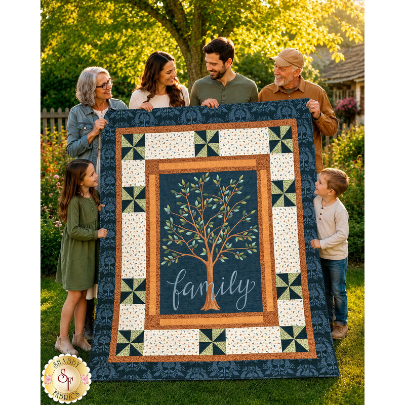The completed Family Tree Patchwork Panel Quilt, colored in blue, cream, and brown fabrics from the Family Tree collection by Moda Fabrics, held aloft by a family in a sunny backyard.