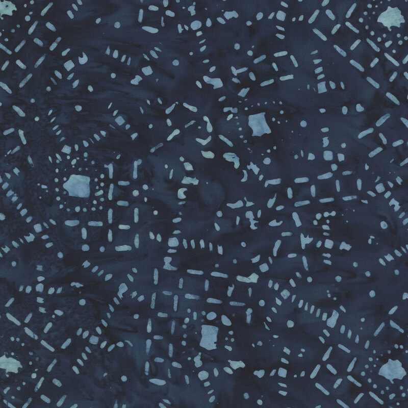 Blue batik fabric with a pattern of abstract geometric motifs and scattered dots.