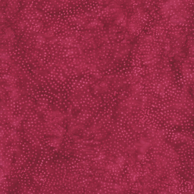 Red batik fabric with a circular pattern of scattered dots.