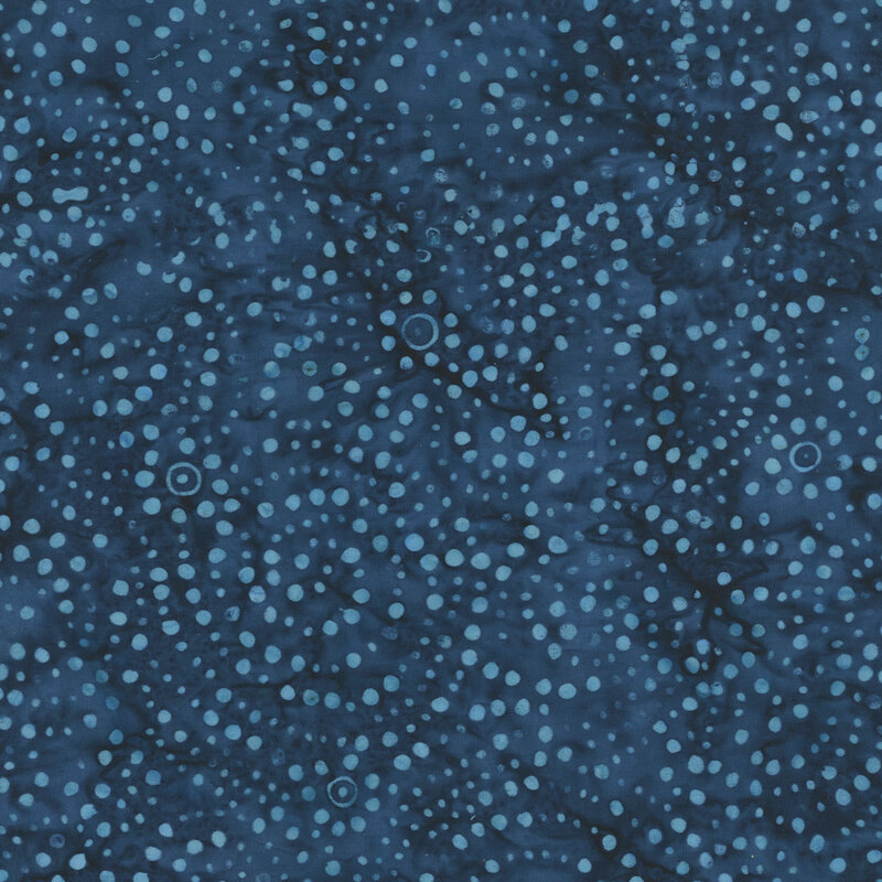 Mottled blue batik fabric with a circular pattern of scattered dots.