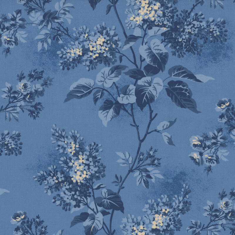 Textured cornflower blue fabric featuring lilac blossoms and foliage in hues of blue and beige.