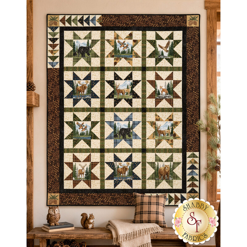 The completed Northwoods Lodge Quilt, featuring rows of patchwork stars paired with panels colored in earthy neutral fabrics, and staged in a cozy cabin setting.