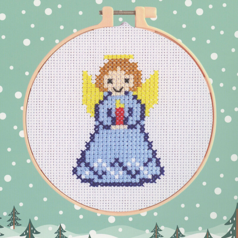 Cross-stitch of a angel set against a light green background with snowflakes.